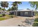 Home with long driveway and well-kept lawn with palm trees and lush landscaping at 170 Argus Rd, Venice, FL 34293