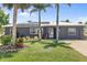 Charming home with a well-manicured lawn, enhanced by solar panels and flourishing palm trees at 170 Argus Rd, Venice, FL 34293