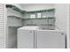 Convenient laundry room with side-by-side washer and dryer, and shelving for ample storage at 170 Argus Rd, Venice, FL 34293