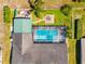 Aerial view of a home with a large screened pool, landscaped yard with fire pit, and a fenced backyard at 18836 Green Park Rd, Hudson, FL 34667