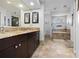 Bathroom with double vanity, granite countertops, tiled floor, soaking tub, and decorative accents at 18836 Green Park Rd, Hudson, FL 34667