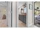 Bathroom with gray cabinets, granite countertops, a framed mirror, and an adjacent patio at 18836 Green Park Rd, Hudson, FL 34667