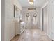 Bright foyer with decorative double doors, tile floors, shiplap walls, and a charming beach-themed decor at 18836 Green Park Rd, Hudson, FL 34667
