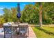 Inviting outdoor patio with dining set, large umbrella, and views of the serene backyard at 18836 Green Park Rd, Hudson, FL 34667