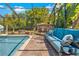 Relaxing pool area with a screened enclosure, features a charming stone fireplace and comfortable poolside seating at 18836 Green Park Rd, Hudson, FL 34667