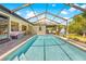 Inviting pool area features a screened enclosure, brick pavers, and a clear view of the lush backyard at 18836 Green Park Rd, Hudson, FL 34667