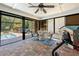 Bright sunroom with brick floors, ceiling fan, pool view, and access to the backyard; great for relaxation and entertainment at 18836 Green Park Rd, Hudson, FL 34667