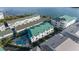 Aerial view of condos with a pool and a boat dock, nestled along the waterway, providing convenient water access at 19817 Gulf Blvd # 602, Indian Shores, FL 33785