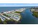Aerial view of waterfront condos, showing private boat docks, beach access, and ocean views in a coastal community at 19817 Gulf Blvd # 602, Indian Shores, FL 33785