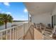 Large, covered balcony with a table and chairs offers stunning views of the water at 19817 Gulf Blvd # 602, Indian Shores, FL 33785