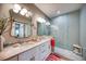 Elegant bathroom featuring double sinks with marble countertops and a glass-enclosed shower with blue accents at 19817 Gulf Blvd # 602, Indian Shores, FL 33785