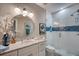 Well-lit bathroom featuring a marble vanity, a round mirror, and a modern glass-enclosed shower with unique tile design at 19817 Gulf Blvd # 602, Indian Shores, FL 33785