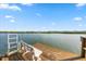 A cozy bench sits on the edge of a wooden pier with fishing gear, overlooking tranquil waters and a distant shoreline at 19817 Gulf Blvd # 602, Indian Shores, FL 33785