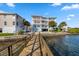 Waterfront condo featuring a private dock and multiple balconies with stunning water views on a clear, sunny day at 19817 Gulf Blvd # 602, Indian Shores, FL 33785