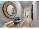 Long hallway with wood-look flooring, decor and art; a decorative mirror reflects light, creating an inviting space at 19817 Gulf Blvd # 602, Indian Shores, FL 33785