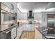 Modern kitchen with stainless steel appliances, granite counters, and white cabinets at 19817 Gulf Blvd # 602, Indian Shores, FL 33785