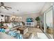 Cozy living room featuring stylish wicker accents, a comfortable beige sofa, and a sliding glass door for natural light at 19817 Gulf Blvd # 602, Indian Shores, FL 33785