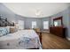 Bright main bedroom featuring a king bed, a dark dresser, and a light blue wall with plenty of natural light at 19817 Gulf Blvd # 602, Indian Shores, FL 33785
