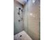 Close-up of a shower with gray and blue tiles, a dual shower head, and a geometric-patterned tile floor at 19817 Gulf Blvd # 602, Indian Shores, FL 33785