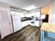 Functional kitchen featuring classic white appliances, white cabinets, and adjacent dining area at 2253 Norwegian Dr # 63, Clearwater, FL 33763