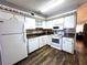 Bright kitchen featuring white cabinetry, black countertops, and checkered decorative trim at 2253 Norwegian Dr # 63, Clearwater, FL 33763