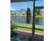 Scenic patio view of a serene pond and lush greenery with other units across the water at 244 Countryside Key Blvd, Oldsmar, FL 34677