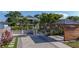 Exterior shot with a paved driveway, gazebo, well-manicured lawn, and tropical landscaping at 2635 13Th N Ave, St Petersburg, FL 33713