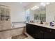 Bright primary bathroom features a double vanity, soaking tub with tile surround, and walk-in shower at 27094 Carolina Astor, Wesley Chapel, FL 33544