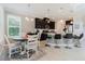 Open kitchen featuring a large island, dark cabinets, pendant lighting, and an adjacent dining area at 27094 Carolina Astor, Wesley Chapel, FL 33544