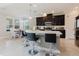 Bright kitchen with an island, dark cabinets, stainless appliances, and an eat-in area overlooking the backyard at 27094 Carolina Astor, Wesley Chapel, FL 33544