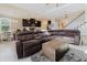 Bright living room features a large sectional sofa and view of the open kitchen and staircase at 27094 Carolina Astor, Wesley Chapel, FL 33544