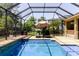 Relaxing screened pool area with lounge chairs, an umbrella, and a refreshing blue pool at 27094 Carolina Astor, Wesley Chapel, FL 33544
