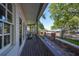 Exterior shot featuring a shaded balcony, offering views of the street and meticulously landscaped yard at 2802 Old Bayshore Way, Tampa, FL 33611