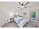 Cozy bedroom with a ceiling fan, carpet and an exterior door with balcony access at 2802 Old Bayshore Way, Tampa, FL 33611