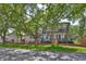 Charming two-story home with a front porch, a balcony, a brick fence, and mature trees at 2802 Old Bayshore Way, Tampa, FL 33611