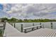 A scenic view of a pier on the water with a bench for seating, providing a peaceful spot to relax and enjoy the scenery at 2802 Old Bayshore Way, Tampa, FL 33611