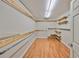 Large walk-in closet with custom wood shelving and ample storage space and wood look flooring at 2802 Old Bayshore Way, Tampa, FL 33611