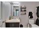 A well-lit bathroom features a vanity with a white sink and a mirror, as well as an overhead light fixture at 2915 Royal Tuscan Ln, Valrico, FL 33594