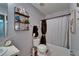 A neutral colored bathroom features a shower/tub combo, toilet, storage rack, and a vanity with a white sink at 2915 Royal Tuscan Ln, Valrico, FL 33594