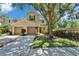Inviting townhome with attached garages, lush landscaping, and a large shade tree at 2915 Royal Tuscan Ln, Valrico, FL 33594