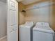 Laundry room with both a white washing machine, white dryer and a wire shelf on the wall at 2915 Royal Tuscan Ln, Valrico, FL 33594