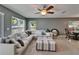 Bright living room featuring a large sectional sofa, an ottoman, carpet floors, and natural light through multiple windows at 2915 Royal Tuscan Ln, Valrico, FL 33594
