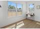 Sunlit room with modern desk, chair, wood floors, and two large windows offering views of the backyard at 3000 19Th S Ave, St Petersburg, FL 33712