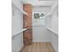 Functional closet space with shelves, a brick accent wall, and a window for natural light at 3000 19Th S Ave, St Petersburg, FL 33712