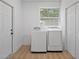 Bright laundry area featuring a modern washer and dryer set, next to a door and window at 3000 19Th S Ave, St Petersburg, FL 33712