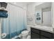 Well-lit bathroom featuring a single sink vanity with black cabinets and a blue ombre shower curtain at 3158 Victoria Inlet Dr, Holiday, FL 34691