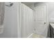 Clean, bright bathroom featuring a shower with a white shower curtain and a neutral-toned tile floor at 3158 Victoria Inlet Dr, Holiday, FL 34691