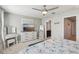 Bright bedroom with a ceiling fan, light gray walls, modern furniture, and an ensuite bathroom at 3158 Victoria Inlet Dr, Holiday, FL 34691