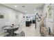 Bright dining area with a round table, white chairs, and tile flooring flowing into an open kitchen at 3158 Victoria Inlet Dr, Holiday, FL 34691