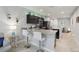 Open-concept kitchen with black cabinets, granite countertops, and bar seating, seamlessly connecting to the living room at 3158 Victoria Inlet Dr, Holiday, FL 34691